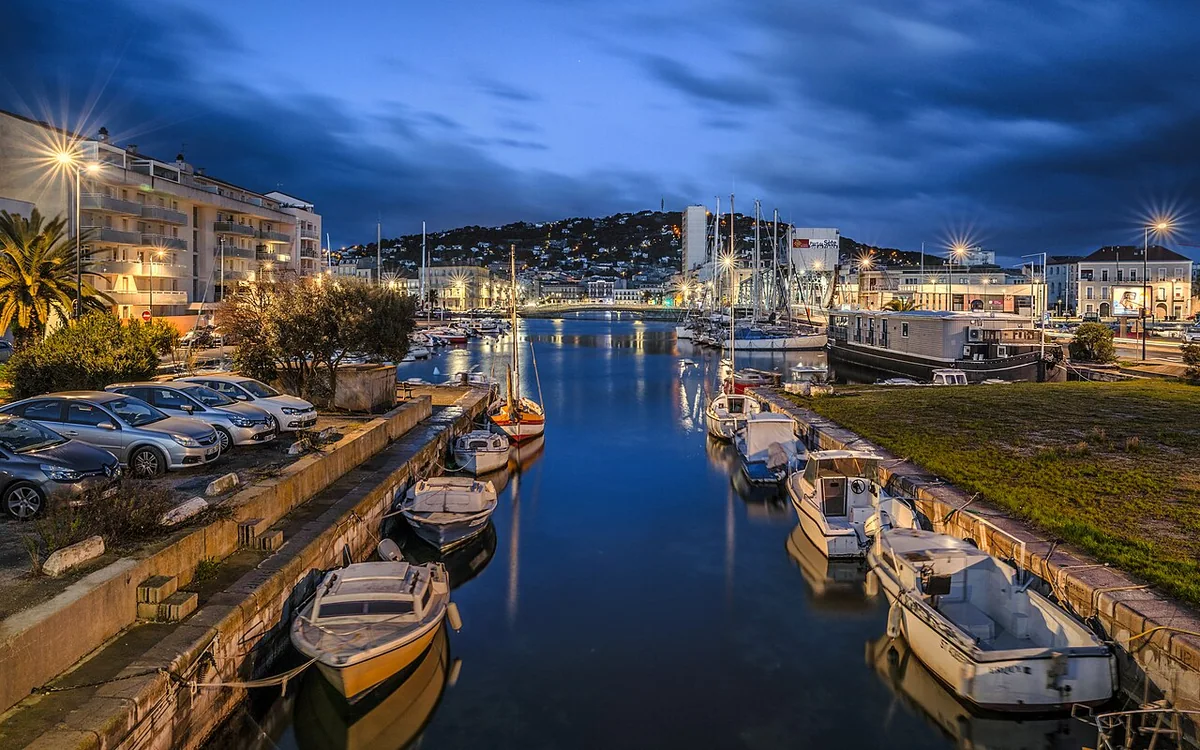 Le canal de la Peyrade et les bâtiments de Sète à l’horizon.