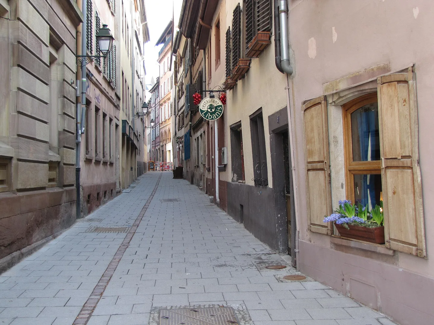 Petite rue des Dentelles à Strasbourg, entre des façades anciennes et une chaussée pavée.