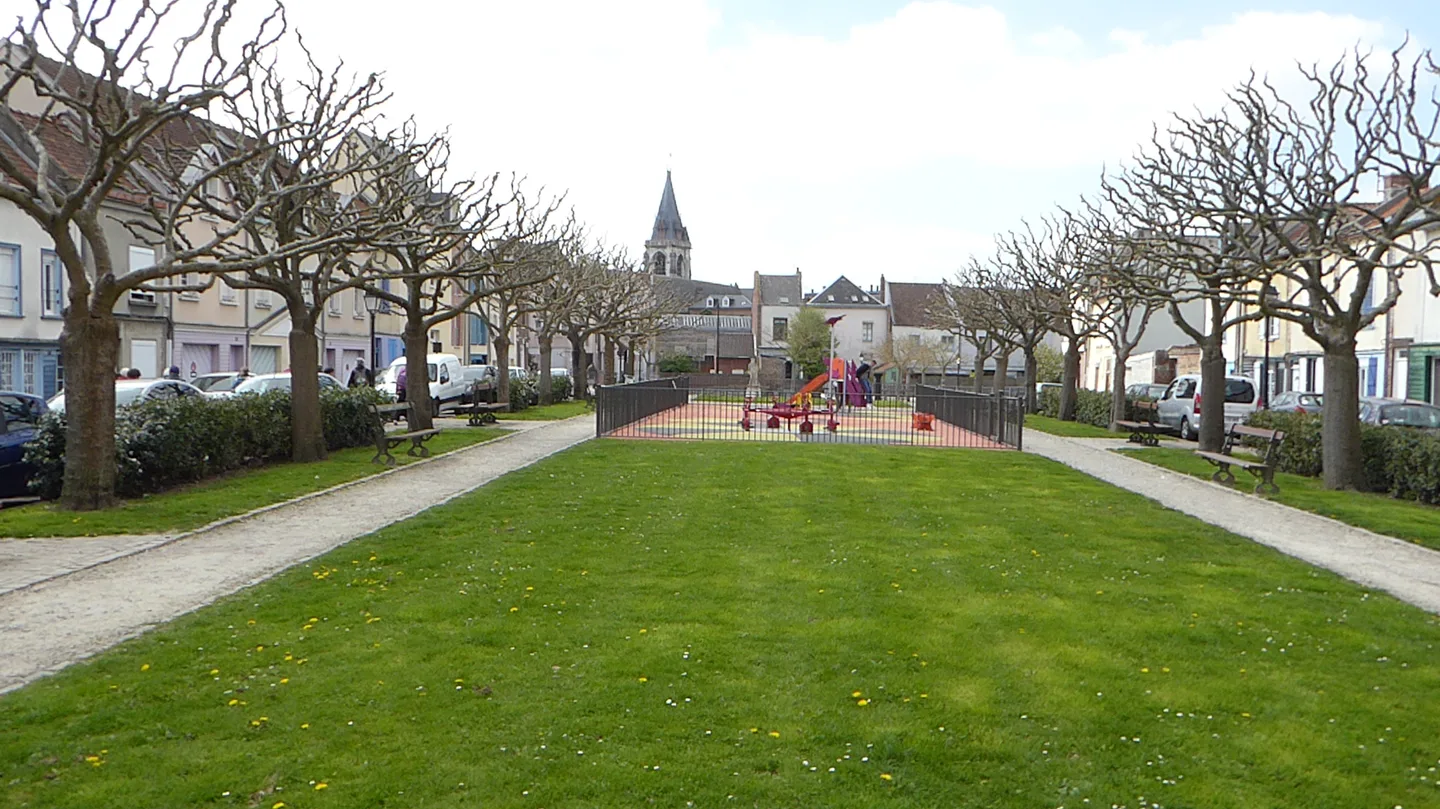 Pelouse, arbres et façades autour de la place Aristide-Briand dans le quartier Saint-Leu à Amiens.