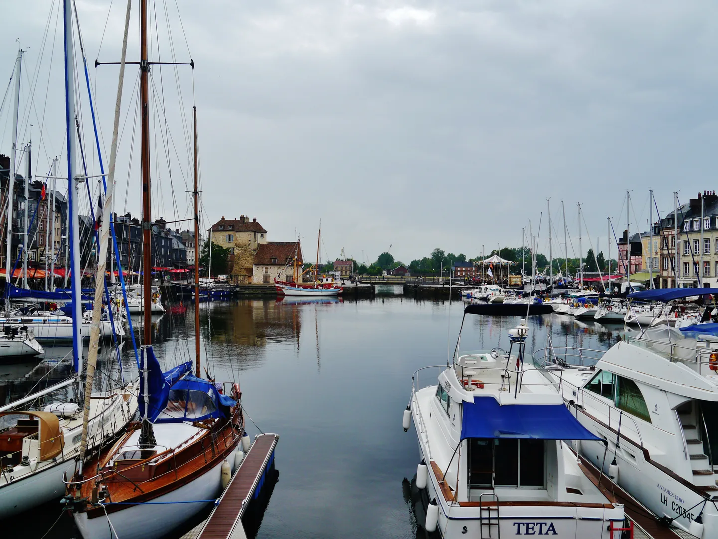 Bateaux amarrés dans le Vieux Bassin d’Honfleur, avec les façades et quais en arrière-plan.