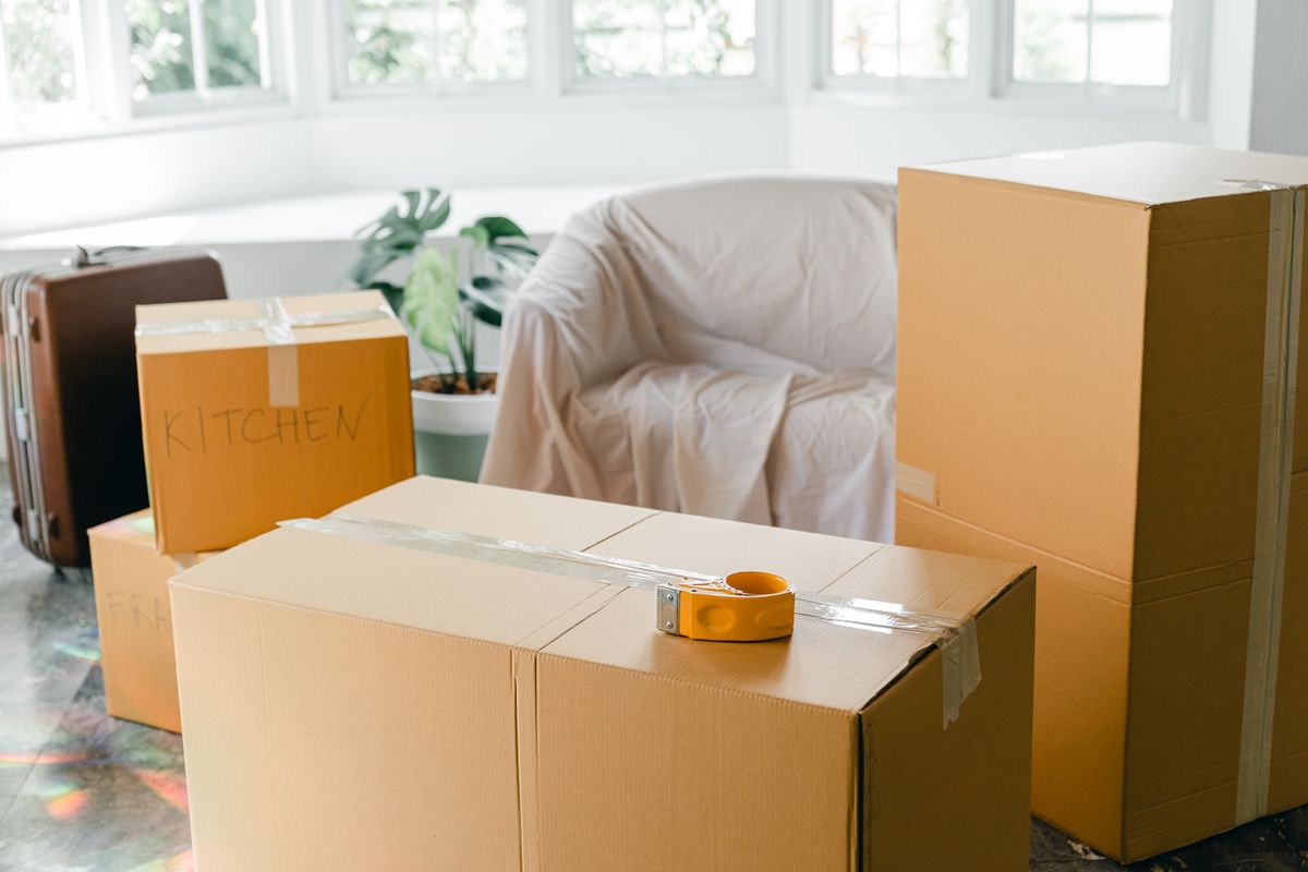 Cartons fermés et meubles protégés dans un logement ; photographie illustrative.