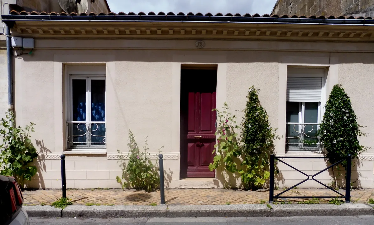 Façade d’une échoppe de plain-pied à Bordeaux-Belcier, avec porte centrale, deux fenêtres et toiture en tuiles.